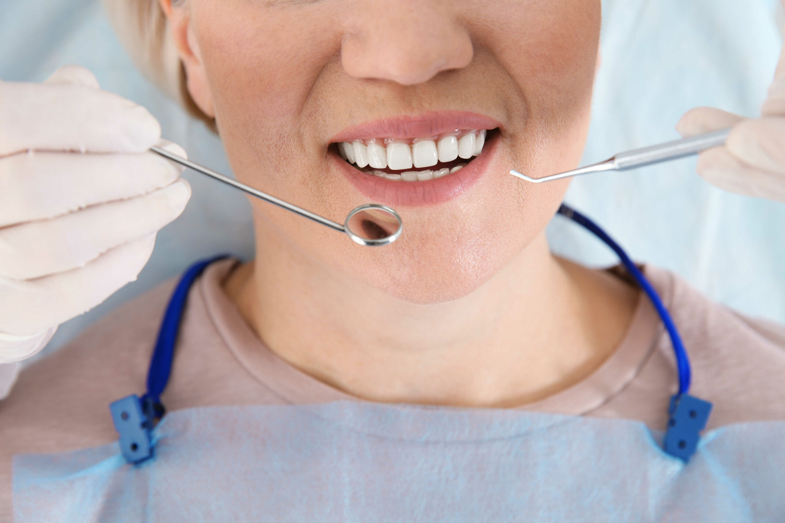 Dentist examining patient's teeth in modern clinic in Warren, MI